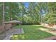 Backyard featuring a wooden pergola, tall trees, and a manicured lawn at 4378 Heritage Glen Ct, Marietta, GA 30068