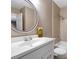A bright bathroom features a large round mirror, and tiled shower/tub at 4378 Heritage Glen Ct, Marietta, GA 30068