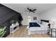 Large bedroom with hardwood floors, a ceiling fan, and a modern accent wall at 445 Westmeath Sw Dr, Atlanta, GA 30310