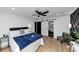 Light bedroom with hardwood floors, a ceiling fan, and a door to the bathroom at 445 Westmeath Sw Dr, Atlanta, GA 30310