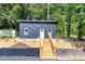 Modern home features a dark exterior and wooden stairs at 445 Westmeath Sw Dr, Atlanta, GA 30310