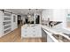 Open kitchen with a sliding barn door, island seating, white cabinets, and marble countertops at 445 Westmeath Sw Dr, Atlanta, GA 30310
