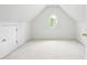 Finished attic space with carpeting, storage, a round window, and neutral walls at 12554 Huntington Trce, Alpharetta, GA 30005