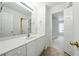 Bathroom featuring a vanity with a large mirror, neutral tile floor, and bright white cabinetry at 12554 Huntington Trce, Alpharetta, GA 30005