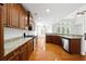 Kitchen with granite countertops, stainless steel appliances and dark wood cabinetry and hardwood flooring at 12554 Huntington Trce, Alpharetta, GA 30005