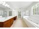 Bright main bathroom featuring a soaking tub, a walk-in shower, and a double vanity at 12554 Huntington Trce, Alpharetta, GA 30005