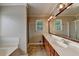 This bathroom has double sinks, a soaking tub, a shower, and a large mirror at 1610 Windsong Park Dr, Dacula, GA 30019