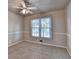 Neutral carpeted bedroom with a ceiling fan and a window bringing in natural light at 1610 Windsong Park Dr, Dacula, GA 30019