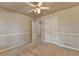 A cozy carpeted bedroom has a ceiling fan and closet; the door is opened to reveal another room at 1610 Windsong Park Dr, Dacula, GA 30019