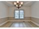Formal dining room featuring a tray ceiling and large window to backyard view at 1610 Windsong Park Dr, Dacula, GA 30019