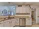 Bright kitchen featuring white cabinets, stainless steel dishwasher, and granite countertops at 1610 Windsong Park Dr, Dacula, GA 30019