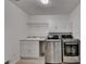 Functional laundry room with stainless steel washer and dryer, sink, and storage cabinets at 1610 Windsong Park Dr, Dacula, GA 30019