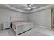 Well-lit main bedroom with tray ceiling, large window, and neutral carpet at 1610 Windsong Park Dr, Dacula, GA 30019