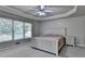 Carpeted main bedroom with large window and tray ceilings bringing in natural light and space at 1610 Windsong Park Dr, Dacula, GA 30019
