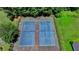 Aerial view of two well-maintained tennis courts, surrounded by lush greenery and trees at 1610 Windsong Park Dr, Dacula, GA 30019