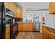 A kitchen with stainless steel appliances, wood cabinets, and access to the living area at 800 Peachtree Ne St # 1504, Atlanta, GA 30308
