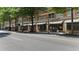 Exterior shot of a commercial building with retail shops and restaurants along a tree-lined street at 800 Peachtree Ne St # 1504, Atlanta, GA 30308