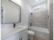 Well-lit bathroom featuring stylish gray tile accents, a modern vanity, and a combo tub-shower at 160 South Village Ave, Holly Springs, GA 30115