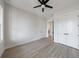 A modern bedroom featuring neutral-colored walls, wood-look floors, a ceiling fan, and ample closet space at 160 South Village Ave, Holly Springs, GA 30115