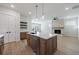 Open-concept kitchen with stainless steel appliances, island, and view of stone fireplace at 160 South Village Ave, Holly Springs, GA 30115