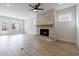 Bright living room featuring a stone fireplace, ceiling fan, and hardwood floors at 160 South Village Ave, Holly Springs, GA 30115