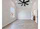 Open bedroom with laminate flooring, a ceiling fan, neutral walls, and a door to the ensuite at 160 South Village Ave, Holly Springs, GA 30115