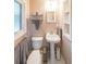 Cozy powder room featuring a pedestal sink, toilet, and decorative mirror at 2889 Mount Olive Dr, Decatur, GA 30033