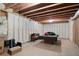 Unfinished basement with exposed wood beams, insulation and concrete floor, and a ping pong table at 344 Nottingham Dr, Marietta, GA 30066