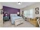 Bedroom with purple accent wall, a rocking horse, and lots of light from the large window at 344 Nottingham Dr, Marietta, GA 30066