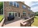 Exterior view of a brick home showcasing a wooden deck with a grill and outdoor dining, steps from the grassy backyard at 344 Nottingham Dr, Marietta, GA 30066