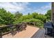 Spacious wooden deck featuring an outdoor dining set and grill, perfect for entertaining with a beautiful tree view at 344 Nottingham Dr, Marietta, GA 30066