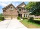 Elegant brick and stone home with a well-manicured lawn and a three-car garage at 344 Nottingham Dr, Marietta, GA 30066