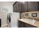 Bright laundry room with dark cabinetry, white washer and dryer, and a utility sink at 344 Nottingham Dr, Marietta, GA 30066