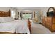 A primary bedroom showcasing an ornate wood bed frame, view to a sitting area, and a dresser at 344 Nottingham Dr, Marietta, GA 30066