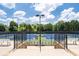 Well-maintained tennis court with a blue and green surface, surrounded by a fence and lush trees in the background at 344 Nottingham Dr, Marietta, GA 30066