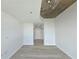 Open living room with bare concrete ceiling, sleek gray flooring, and pristine white walls at 361 17Th, Chattahoochee Hills, GA 30363