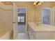 Bathroom featuring a vanity with white cabinets, a tub with tile surround, and an open doorway to bedroom at 4924 Locklear Way, Marietta, GA 30066