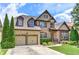 Charming two-story home featuring a stone and brick facade, manicured lawn, and a two-car garage at 4924 Locklear Way, Marietta, GA 30066