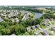 Beautiful aerial view of a residential community with mature trees and a serene lake on a sunny day at 6045 Stargazer Way, Cumming, GA 30028