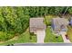 Aerial view of home with well-manicured landscaping, a long driveway and a two-car garage in a tree filled neighborhood at 6045 Stargazer Way, Cumming, GA 30028