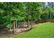 The backyard has a fully fenced play area with trees and lush landscaping at 6045 Stargazer Way, Cumming, GA 30028