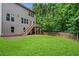 Large, well-manicured lawn in a fenced backyard, complete with a wooden staircase and lush green trees at 6045 Stargazer Way, Cumming, GA 30028