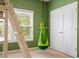 A green room features a hammock chair, closet and window for the natural lighting at 6045 Stargazer Way, Cumming, GA 30028