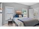 Bright bedroom includes a bed, two windows for lots of natural light, and a modern bedside table at 6045 Stargazer Way, Cumming, GA 30028