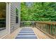 Cozy wooden deck with a blue striped rug and seating, offering a relaxing outdoor space with green view at 6045 Stargazer Way, Cumming, GA 30028