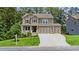 Attractive two-story home featuring a welcoming front porch, three-car garage, and a green lawn at 6045 Stargazer Way, Cumming, GA 30028