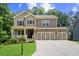 Inviting two-story home with a covered porch, manicured lawn, and a convenient three-car garage at 6045 Stargazer Way, Cumming, GA 30028