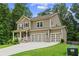 Beautiful two-story home boasts a covered front porch, lush lawn, and a spacious three-car garage at 6045 Stargazer Way, Cumming, GA 30028