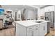 Open-concept kitchen with a large island, stainless steel appliances, and a view of the living area and staircase at 6045 Stargazer Way, Cumming, GA 30028