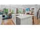 Spacious kitchen with white cabinets, large island with seating, and stainless steel appliances, seamlessly connected to the dining and living areas at 6045 Stargazer Way, Cumming, GA 30028